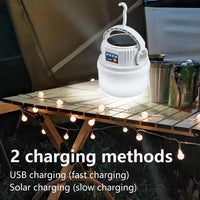 LED Solar Camping Light Solar Bulb Lanterns Rechargeable Portable Waterproof Outdoor Night Flashlight BBQ Hanging Emergency Lamp on a table.